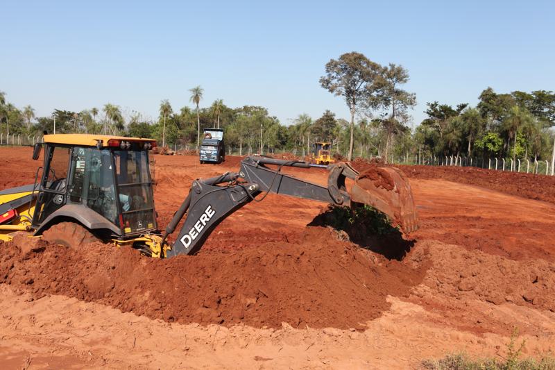 Retroexcavadora en movimiento de suelo sobre tierra roja
